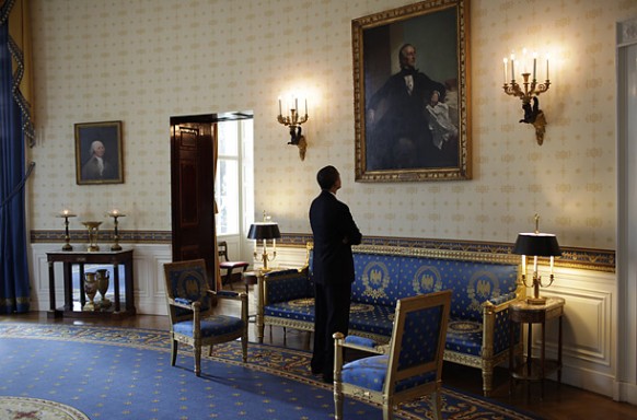 obama looking at one of the paintings in his office