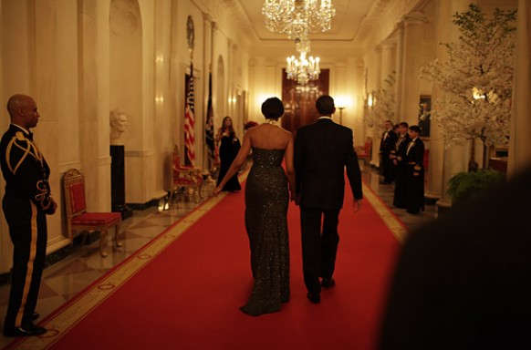 obama with michelle walking down a whitehouse corridor