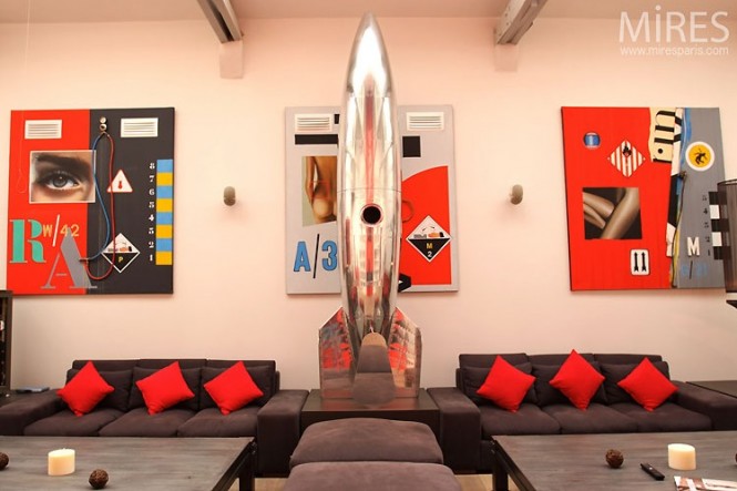 metal spaceship sculpture and red and black wall art in paris loft
