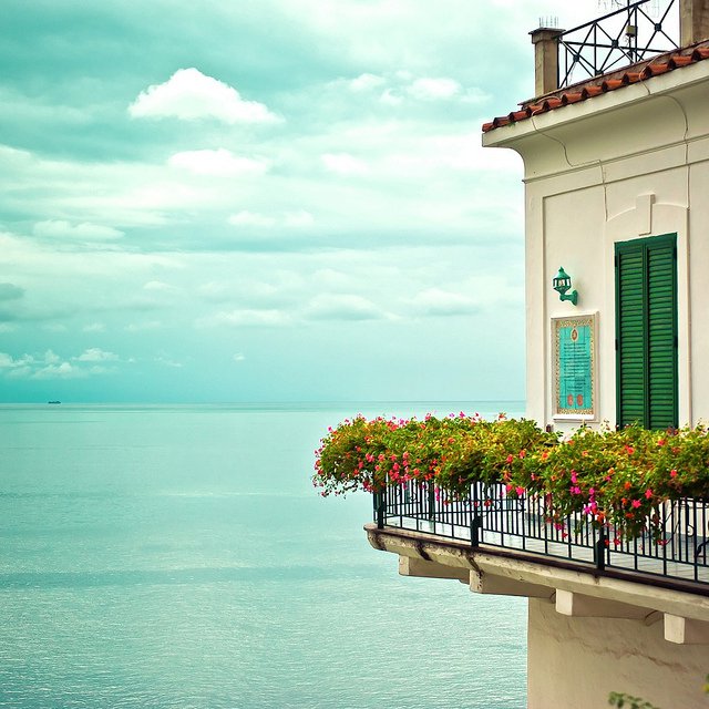 Can you imagine standing on this balcony that practically hangs over clear blue waters? via