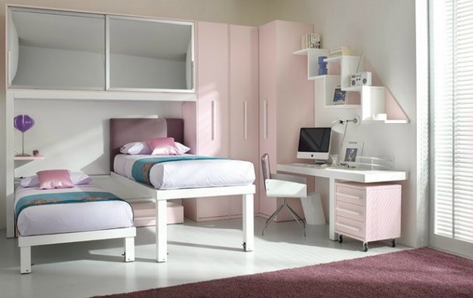 This pink and white girls' room compacts two beds, a desk, storage, and closet space all in one small space with little girl-appropriate design.
