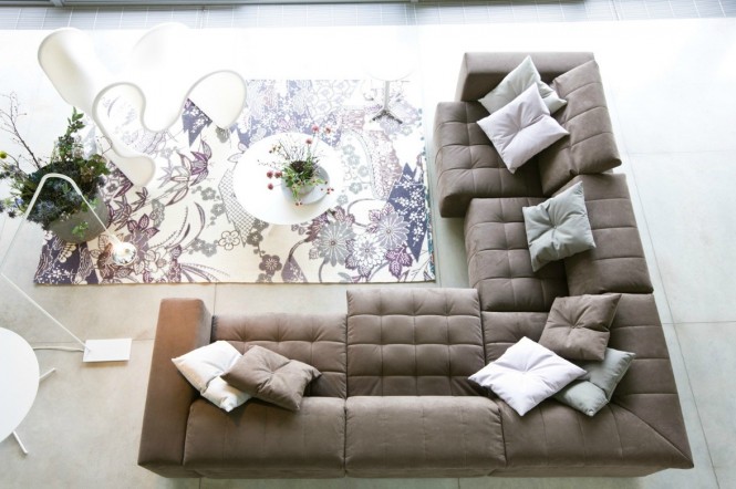 The beige couch looks quite versatile. Make it homey and sweet with a floral print rug, or eliminate the rug and substitute with dark pillows, and it will instantly become more modern and serious.