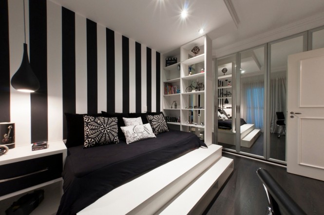 We're also seeing a continuing trend in wide stripe treatments for walls, with emphasis on the monochrome theme, take this bedroom for example; we love these gutsy black and white lines that create an extended headboard feature on one wall. The head of the bed is the perfect place to make a statement in a bedroom, you can be daring and create dazzling impact, but the stimulating design will be out of your eye line when you are trying to relax! The linear pattern is also picked up in the steps at the foot of the bed, which create a lovely grand feeling, and the original placement of the very practical open shelving system to the bedside.