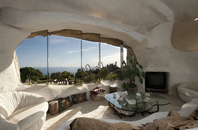 The interior of the Stone Age styled pad is linked to exterior beauty by way of large expanses of glass nestled in naturally irregular shaped surrounds, frameless and organic in appearance, through which the tantalising views of sea and mountain can be absorbed.