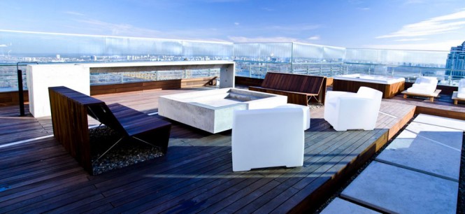 The top floor of the apartment is home to a huge rooftop terrace that enjoys panoramic views from a generous sun deck, a fire pit seating zone with handmade plank benches., or from a glass walled pavilion in more wintry weather.