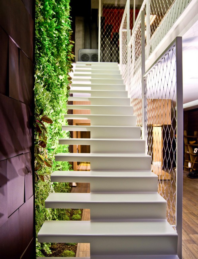 A green wall of plants grows vertically through the home, to bring the softness of nature into the manmade environment, running from the living-dining space down to the lower floor containing the lounge-home office space, plus the secondary living area that leads to the spacious master bedroom.