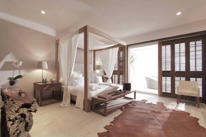 A romantic bedroom scheme greets you with a fairytale of a four-poster bed, complete with soft flowing drapes and fresh white bed linen. A cowhide rug spans the floor space to create a little warmth underfoot, amidst the cool marble floor.