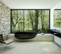 A glossy pebble shaped bathtub emerges from a solid concrete surround for a stunning contrast of style.