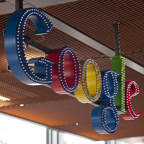 Dozens of miniature lights illuminate the outline of the colorful Google logo over the reception area.
