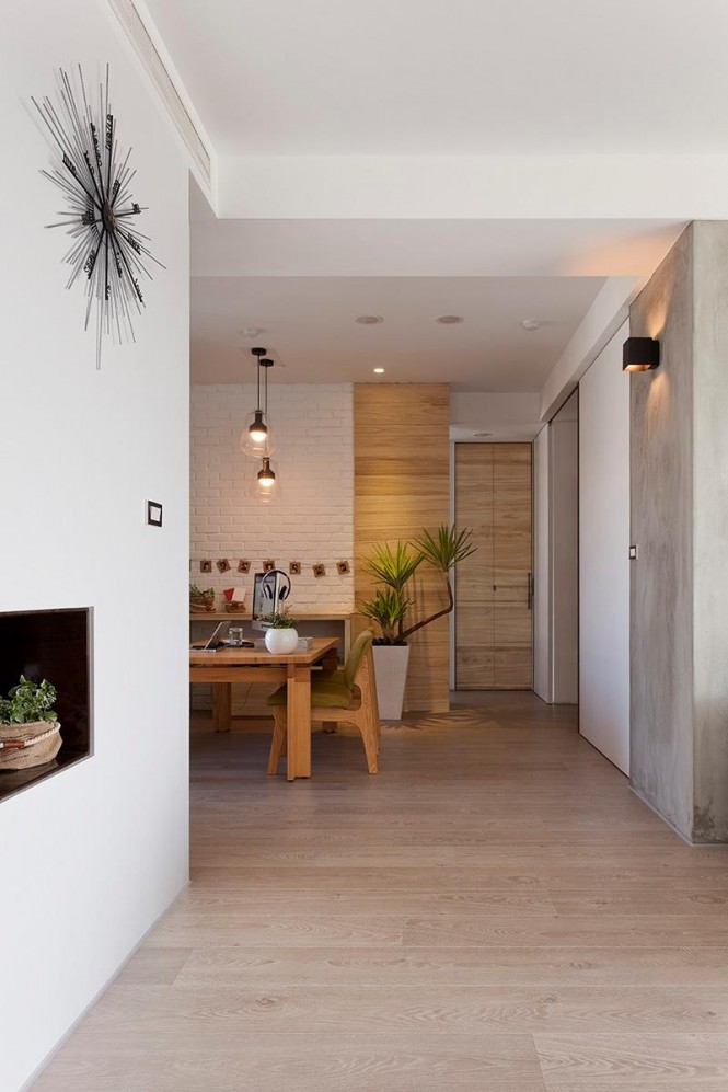 Wood cladding has also been taken up and over the walls to bring more warmth into the minimally decorated apartment, and much of the furniture employs a complimentary grain.