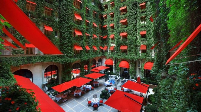 This striking color combination of cherry red sun awnings, parasols and dining seats against a dense covering of exquisitely lush ivy is the scene that will meet you at the swish Hôtel Plaza Athénée in France.