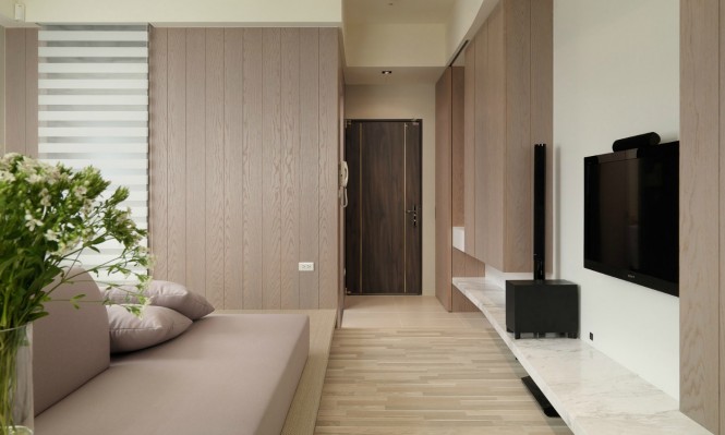 A wall of wood cladding matches the finish of the wooden cabinetry to achieve continuity of materials and color.