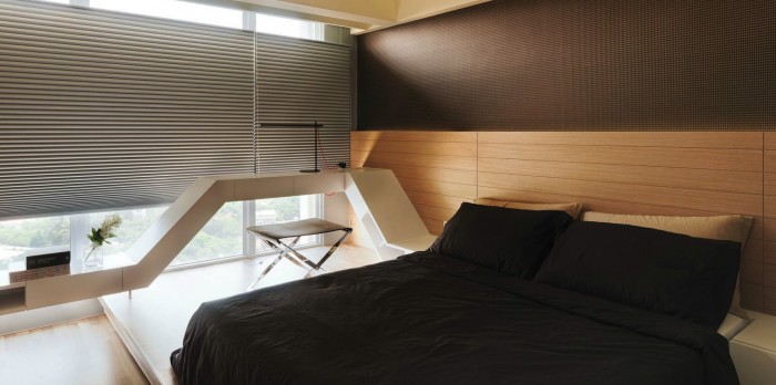 The platform bed of this room is framed in such a way that the headboard continues along the window wall acting as a desk and onto the opposite wall as a dresser.