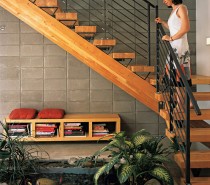 Dwell indoor fish pond viewed from rich wooden staircase