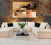 To begin with a neutral palette, like this creamy sofa and rug ensemble, we can see that the series of swatches across the canvass picks up not only the paler hues, but works through the spectrum to tie in every shade right through to the black accent cushions. Of course, your wall art doesn't have to appear as a spectrum, but look for pieces that work all the way though your color story, from light to dark.