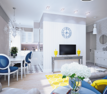 The open plan living area is arranged around a central column where a subtle gray console table is brightened by two sunshine yellow vases at each end. The colorful additions are contrasted by a blue wall clock above the flatscreen TV.