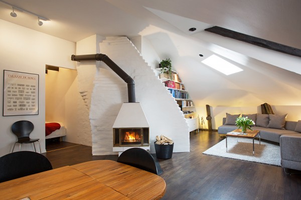 A large white wood-burning stove offers heat to the lofty open plan apartment.