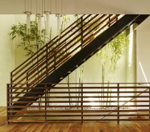 A narrow strip of landing space is utilized in this home with the installation of a long planter, enabling the planting of a path of bamboo that stretches up the staircase.