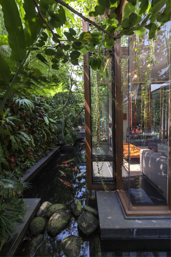 Lush green areas hug this home, and indeed the home hugs them right back: the construction is built around, and criss-crosses the path of natural beauty over an area of 342 square meters.