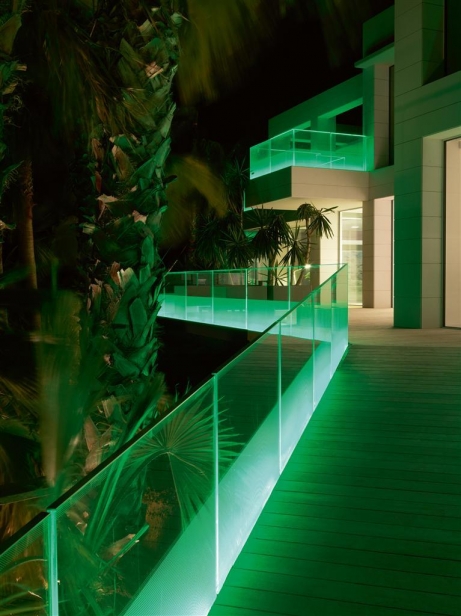 The LED lighting scheme continues outside of the building, where lighting strips color the decks and walkways with glowing glass balustrades.