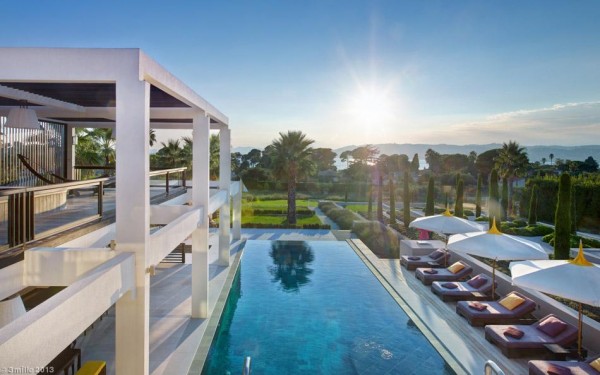 Beyond the holiday home's large gardens with mature palm trees and shrubs, the glorious view continues all the way out to the sea. A bank of sun loungers are set to soak up the suns rays on a deck that runs alongside a generous infinity pool.
