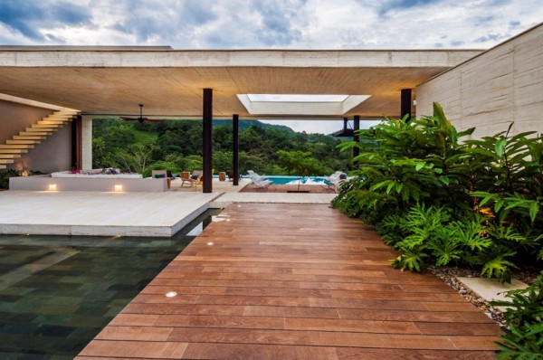 As you enter the home, a narrow, low entranceway builds curiosity as to what lies ahead, before the dimensions burst open onto the main social area of the home where sweeping views out to the mountains are framed to wow beyond the patio. The main social area appears to almost float on water, thanks to the large water feature at the front entrance and the pool at the back of the property.