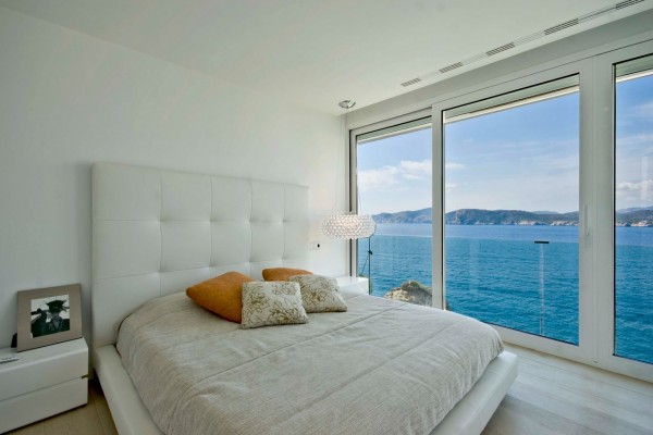 The bedrooms of this holiday home are sleek and stylish, colored only by the aqua view.