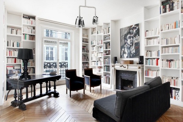 This apartment, with its wrought iron balcony railing and floor-to-ceiling bookshelves is indicative of the French way of life. Reading, relaxing, and celebrating beauty. The black furnishings are another popular theme throughout these French homes.