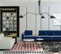The living room has multiple funky focal points starting with a blue velvet sofa and a mishmash of prints on the rug.