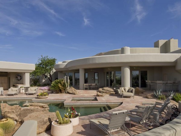 The flat roof and pale beige adobe-style exterior is firmly situated in the classic Southwest style.