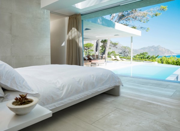 The cozy white linens and simple bed frame all but melt away in view of the spectacular pool and far away mountains.