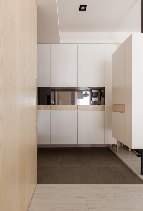 A reflective backsplash makes the narrow kitchen seem bigger and super modern.
