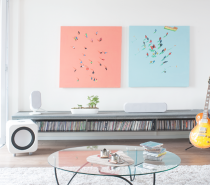The eye can't help but be drawn to the pretty pastel wall art in this living room. You don't even miss the TV.