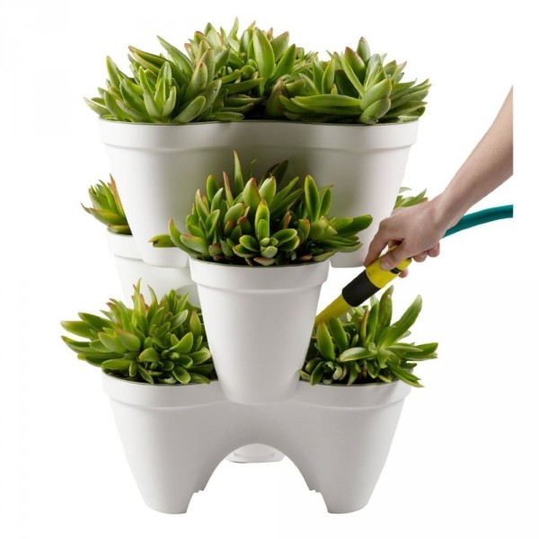 A tiered planter like this one saves space, protects plants with a watering reservoir, and lets you mix and match different succulents, flowers, or herbs.
