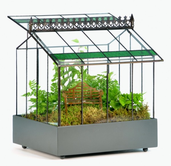 A tiny terrarium that looks like a greenhouse is both art piece and planter at once.