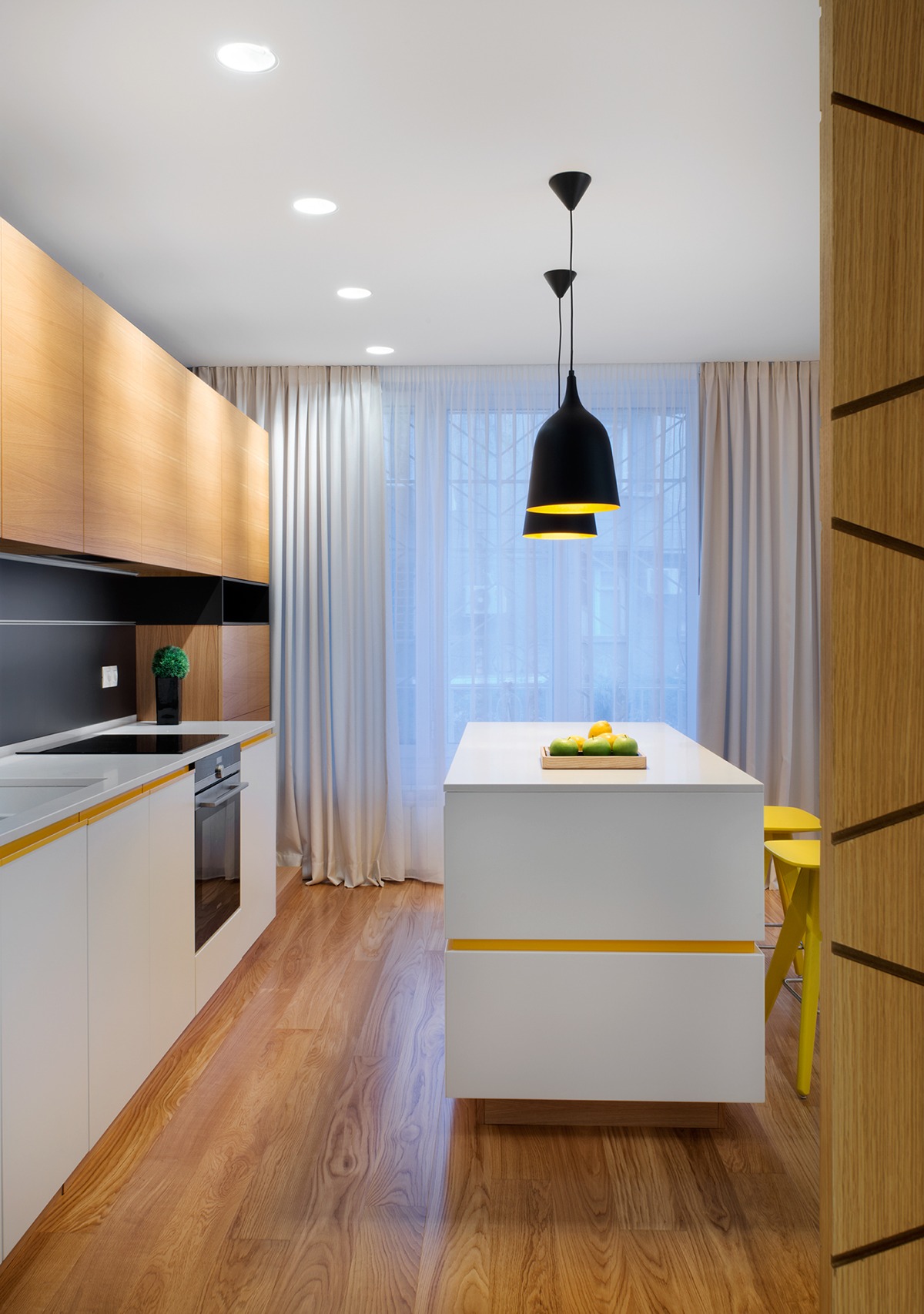 Bands of yellow brighten the sleek and modern kitchen space while