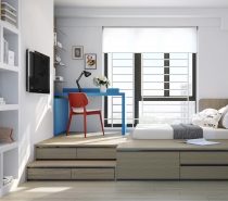 This youngster's room encourages study with a bright desk in primary colors. Drawers expand the functionality of the bed platform, raising the main bedroom area up to window-level.