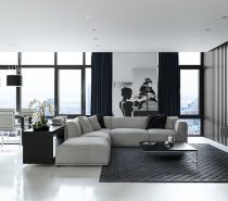 Sergey Baskakov’s visualisation of a private interior in London, England, shows how imagery and shapes can add spice to simple materials. In this lounge and dining area, two wide-panned photographs centre the room, while rounded white and grey surfaces contrast against rectangular black. White orchids add life.