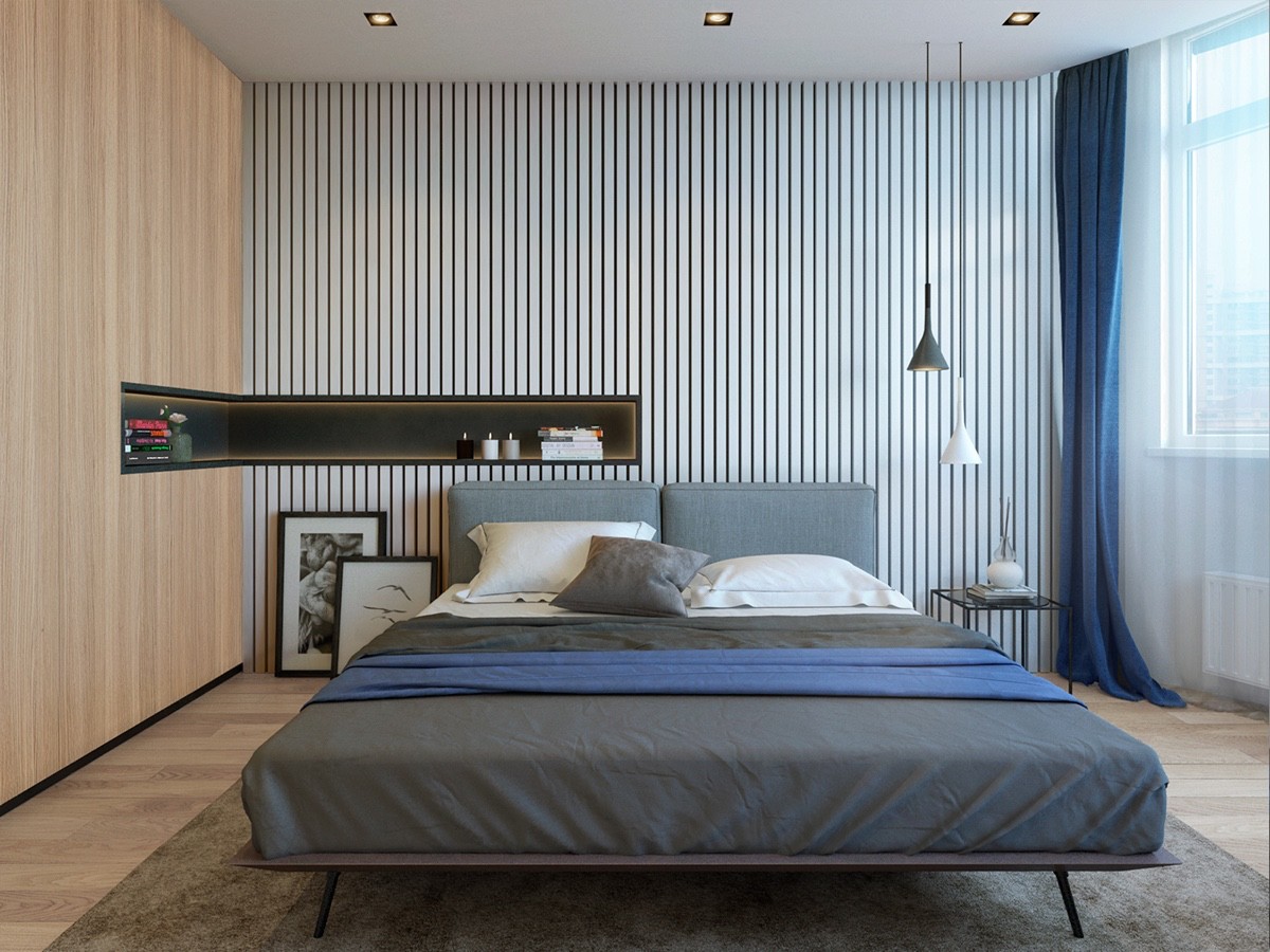 Twin minimalistic backgrounds create space and interest in the bedroom. A thin, horizontal wall inlet provides the space of a bedside table without the clutter, while midnight blue covers and rich terracotta upholstery adds warmth.