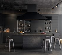 Almost all-resplendent in black, a few minor elements shine in chrome and wood. Textures do the talking in a matte table under, granite bench and black wood-panelled walls.
