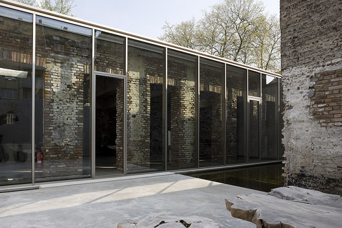 The warehouse conversion sparked an interesting plan to allow light to penetrate into central living spaces from each side; to create dramatic effect and brighten the core, a shiny glass facade stands independently of the structure, contrasting with ancient walls and preserving the history.