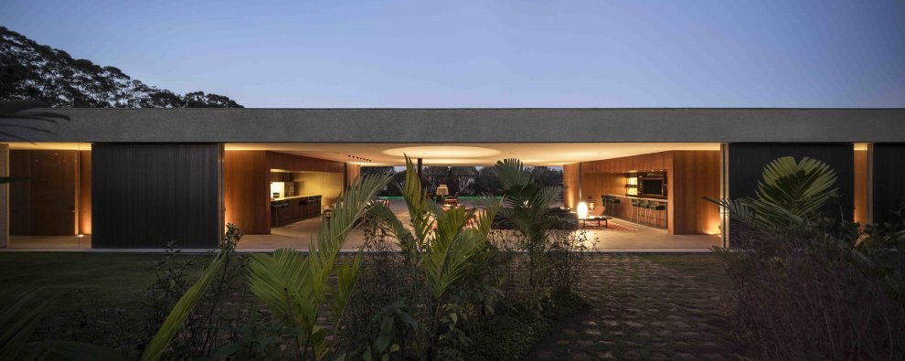 Marcio Kogan's Casa Lee Concrete House- exterior in the evening entrance  with palms | Interior Design Ideas
