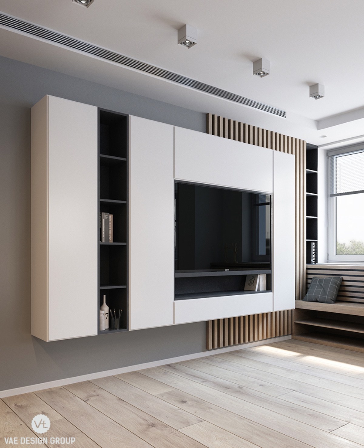 From behind the couch, a monochromatic panel housing TV and entertainment essentials meets the eye. Light wooden flooring, muted grey walls and a lack of clutter help it dominate the space.