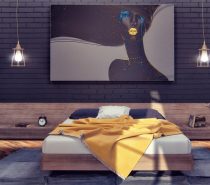 The designer dubbed this apartment "Hello-Yellow" and this beautiful bedroom gives a good example of the name's intent. Artwork, accent wall, and even the floors are dark, lending even more drama and pop to the soft yellow accents like the lips on the painting and the dandelion gold throw blanket on the bed. The painting, of course, brings the distinctive color theme together flawlessly – its colorful details much more vivid than the textile palette it mimics. To balance out the room's surreal style, straightforward industrial lighting and furniture remain relics of the world outside.